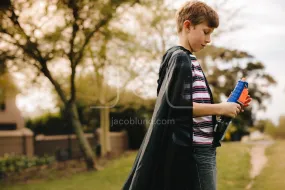 Boy with cape pretending to a superhero